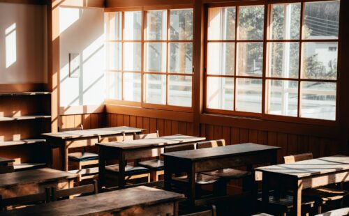 Empty Classroom with Wooden Desks and Windows